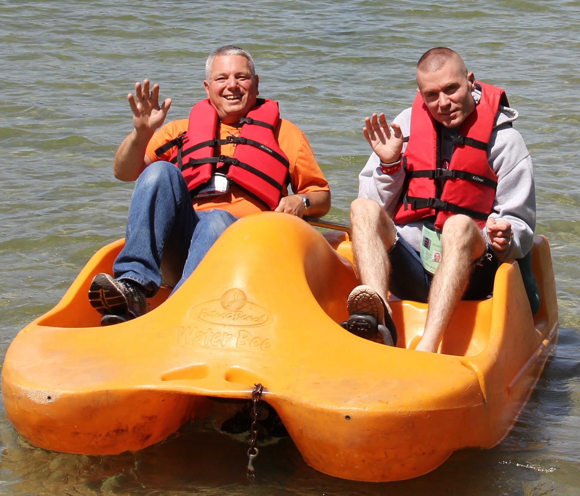 Two guys in a paddleboat waving