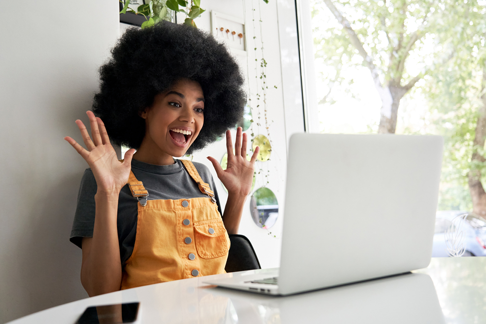 Woman laughing at someone on the laptop in front of her