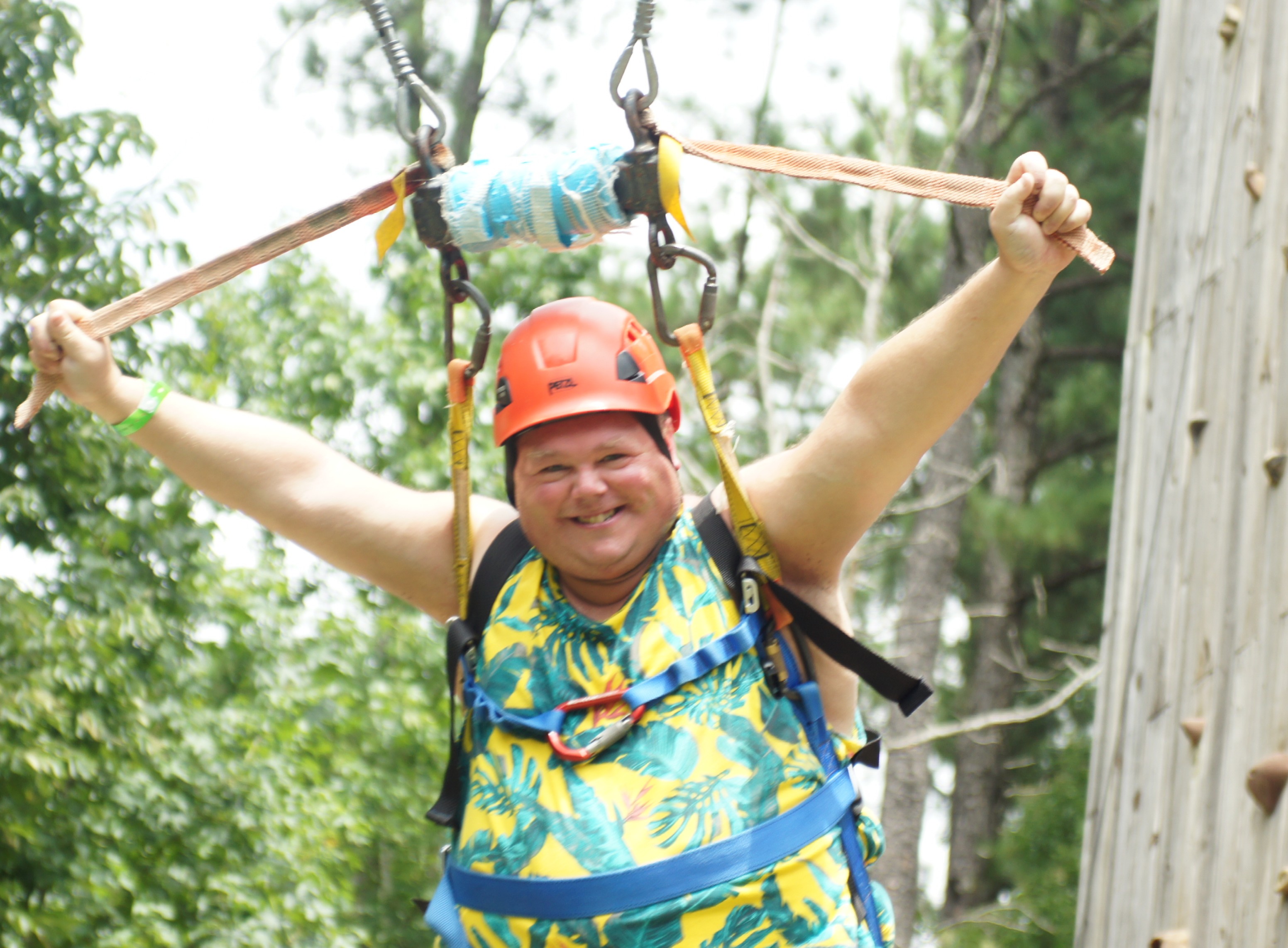 One boy gliding down a zip line smiling