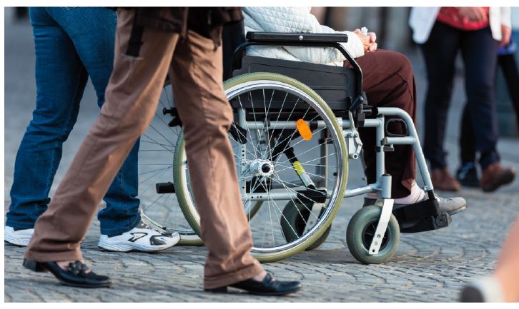 Person sitting in a wheelchair in a crowd of people