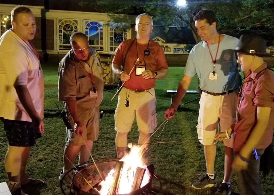 Men around a campfire with marshmellows