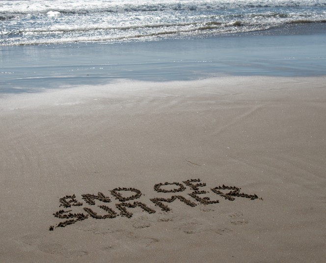 Picture beach with End of summer written in the sand