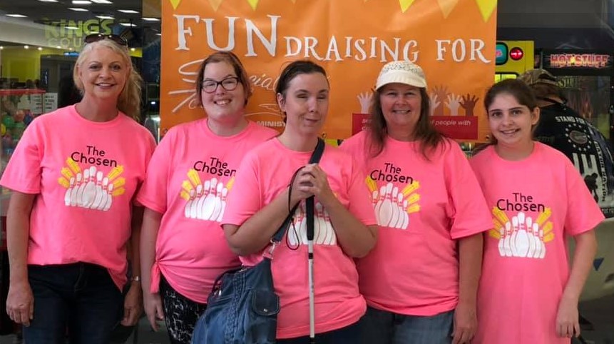 Group picture of team of woman bowlers including woman with white cane