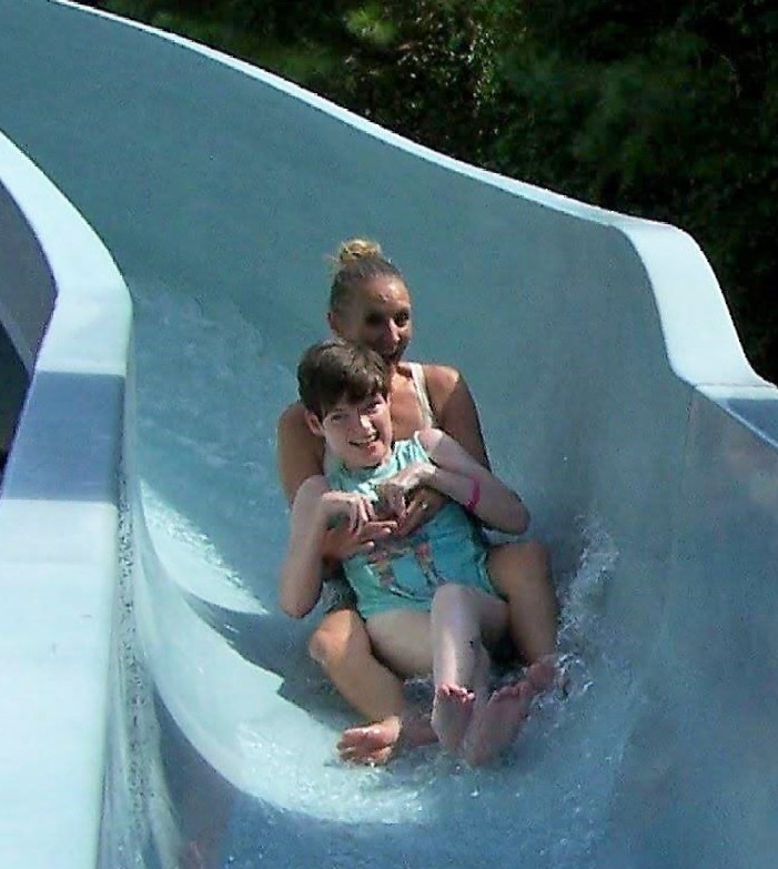 Two people going down a water slide laughing