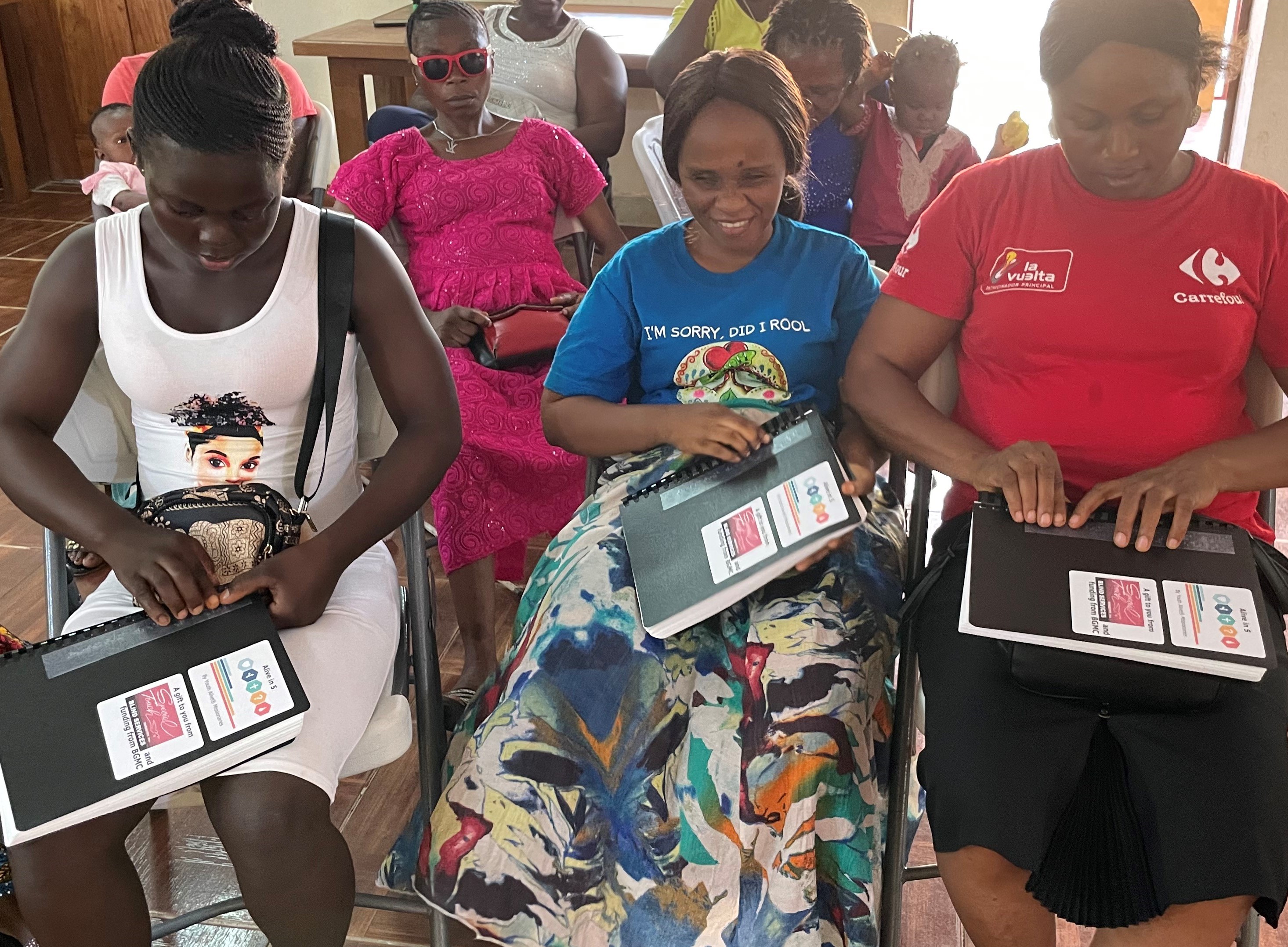 A group of woman, many who are reading the Braille Alive in Five 