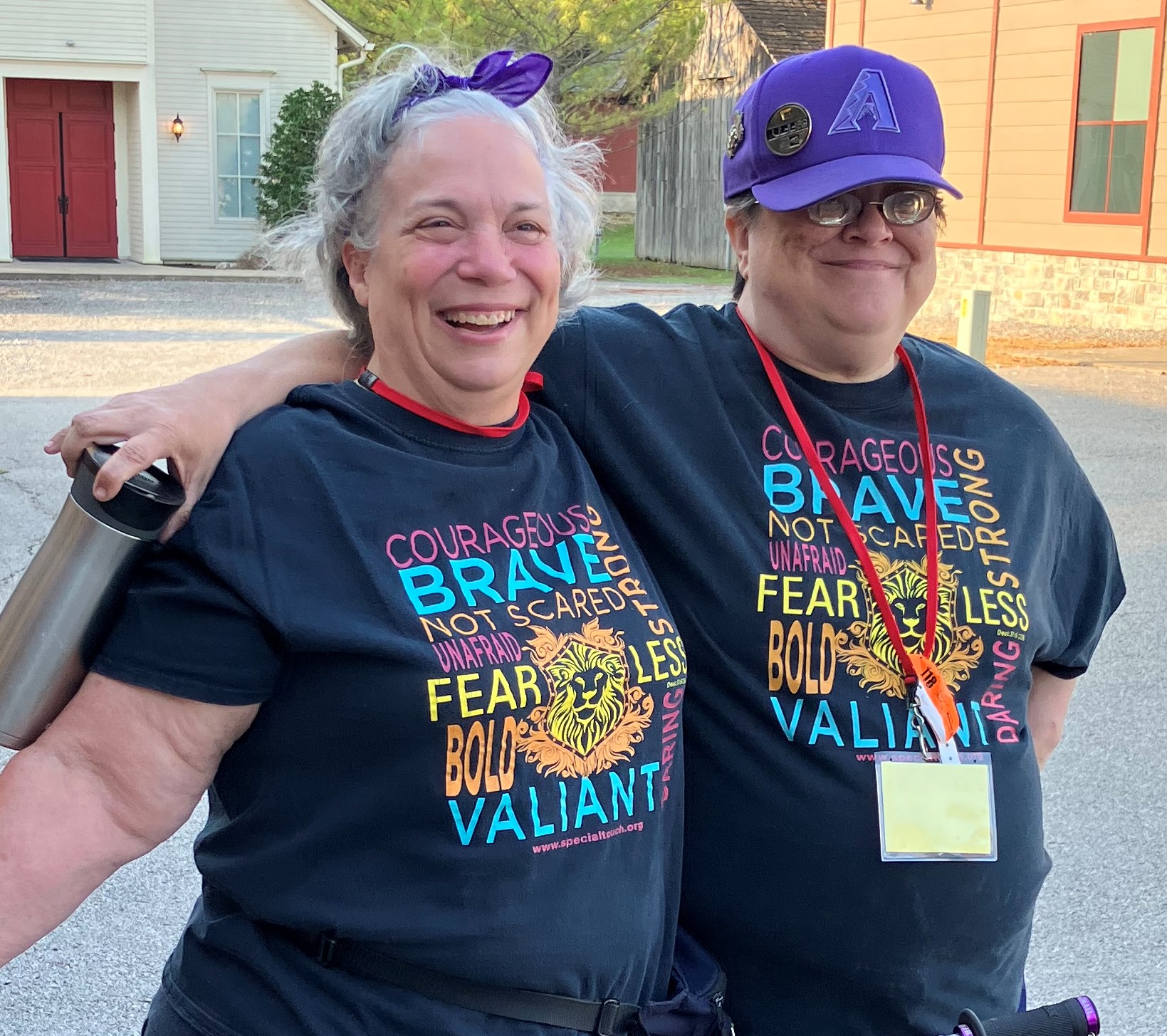 Two woman smiling wearing the same Special Touch fearless tshirt