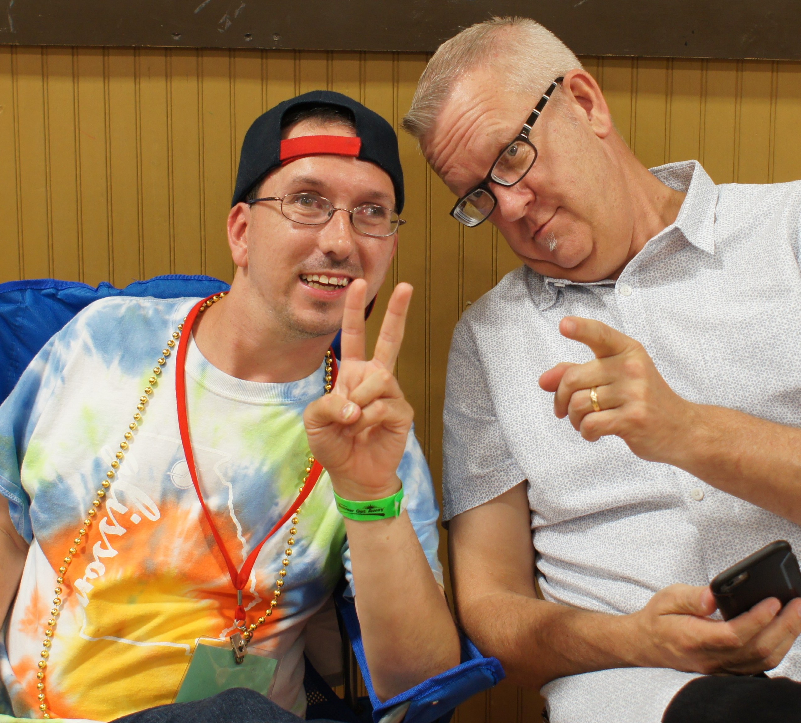 One guy pointing at you and guy smiling and holding up the peace sign