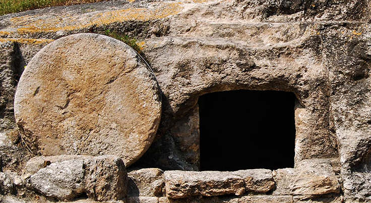 Dark tomb or cave with a round stone on front side of opening