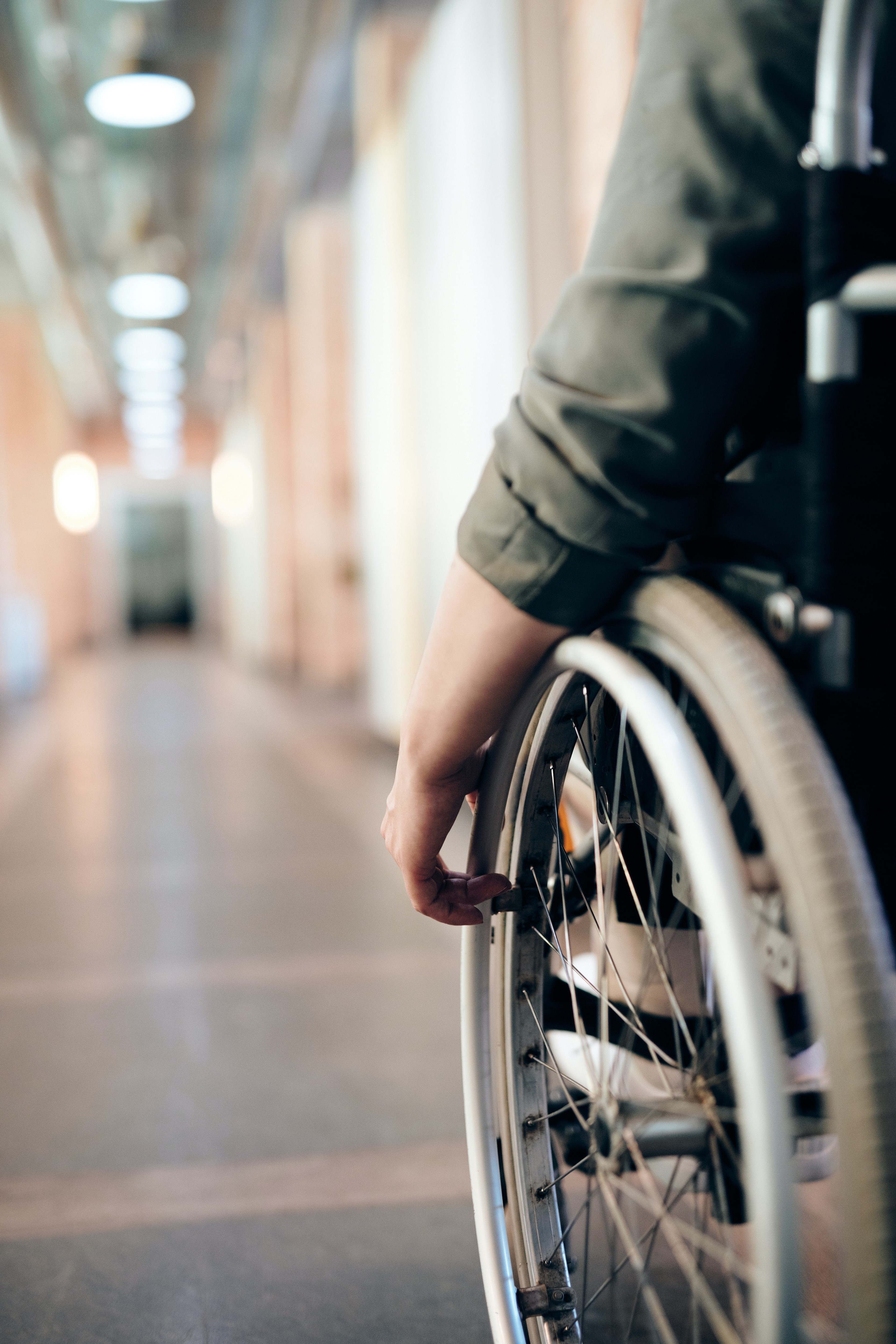 Person in a wheelchair sitting in an empty hallway